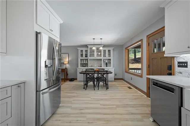 a kitchen with stainless steel appliances granite countertop a refrigerator and a stove top oven