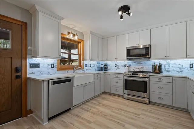 a kitchen with granite countertop appliances cabinets and a sink