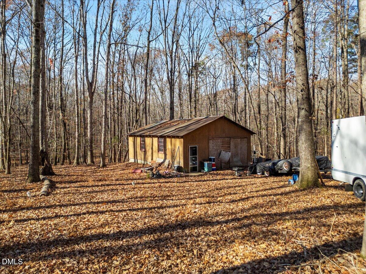407 Mountain Brook Road Rougemont, NC 27572 - Photo 21 of 23 a wooden house with trees in front of it