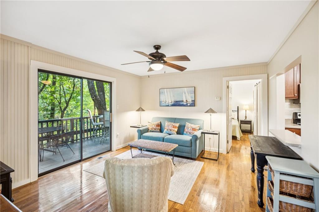 a living room with furniture and a large window with wooden floor