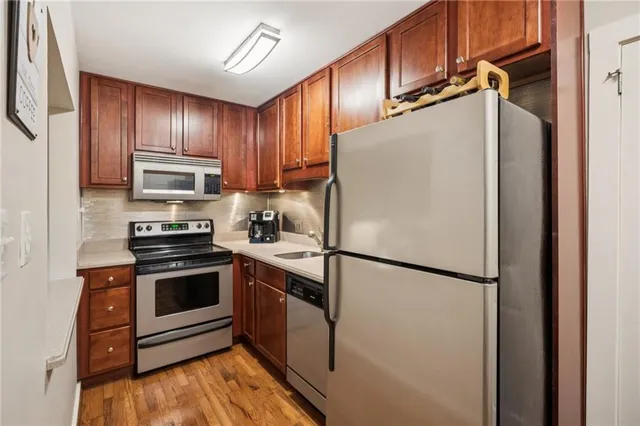 a white refrigerator freezer and a stove sitting inside of a kitchen