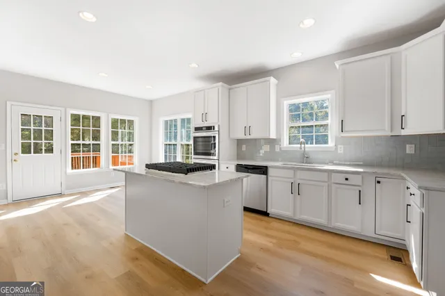 a kitchen with stainless steel appliances granite countertop a stove and a sink