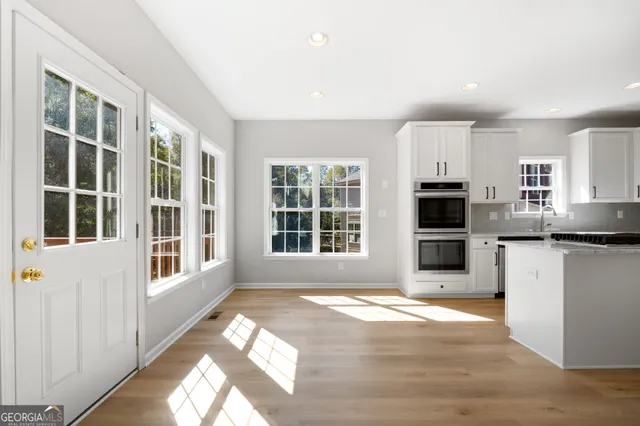 a view of large kitchen with granite countertop refrigerator oven a sink and dishwasher with wooden floor