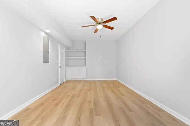 a view of empty room with wooden floor