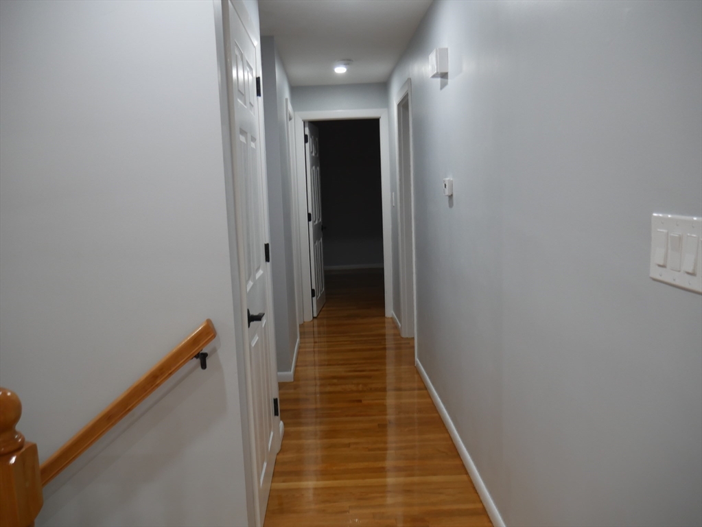 29 Styles Drive Peabody, MA 01960 - Photo 22 of 41 a view of a hallway with wooden floor and staircase