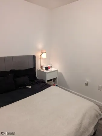 a bedroom with a bed and a flat tv screen on dresser