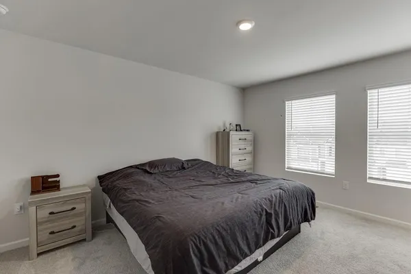 a spacious bedroom with a bed and a window