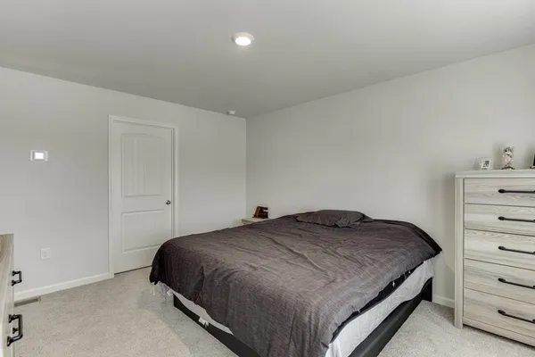 a bedroom with a bed and cabinet