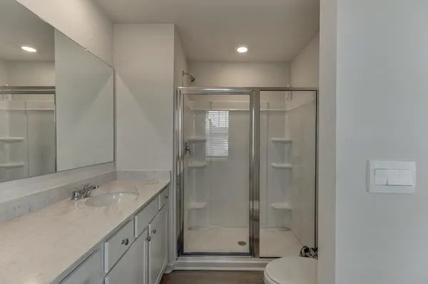 a bathroom with a shower sink and mirror