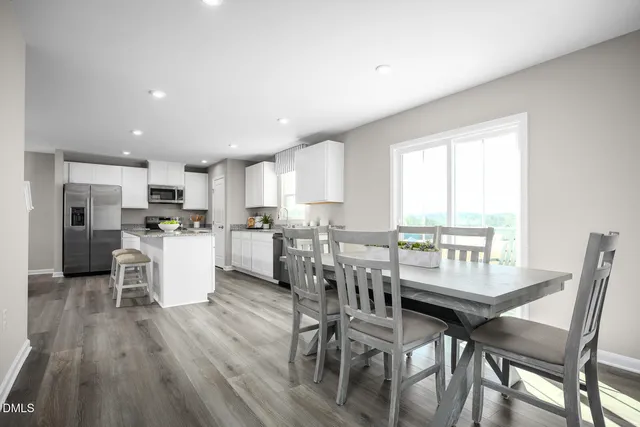 a kitchen with kitchen island granite countertop a sink cabinets stainless steel appliances and a window