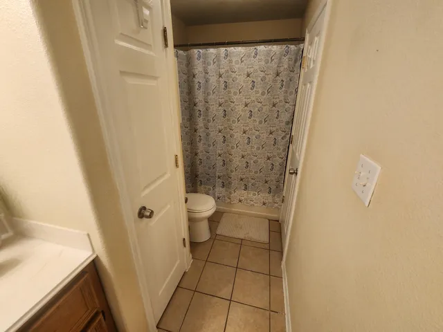 a bathroom with a granite countertop shower and a toilet