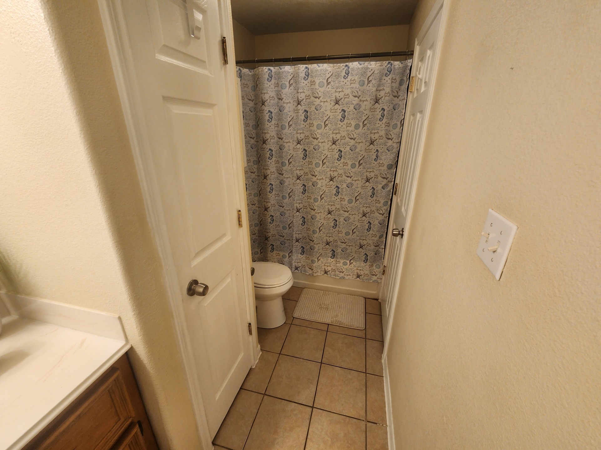 215 Postoffice Street, Unit 1005 Galveston, TX 77550 - Photo 10 of 16 a bathroom with a granite countertop shower and a toilet