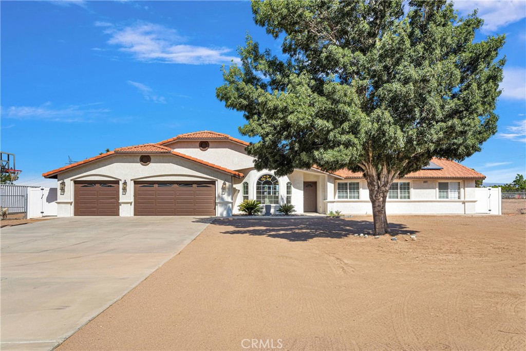8621 Aster Road Oak Hills, CA 92344 - Photo 1 of 54 a front view of a house with a yard and garage