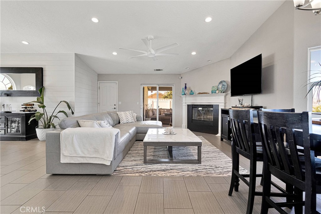 8621 Aster Road Oak Hills, CA 92344 - Photo 11 of 54 a living room with furniture a flat screen tv and kitchen view