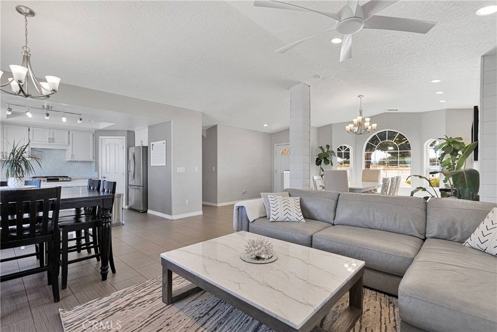 8621 Aster Road Oak Hills, CA 92344 - Photo 12 of 54 a living room with furniture kitchen view and a chandelier