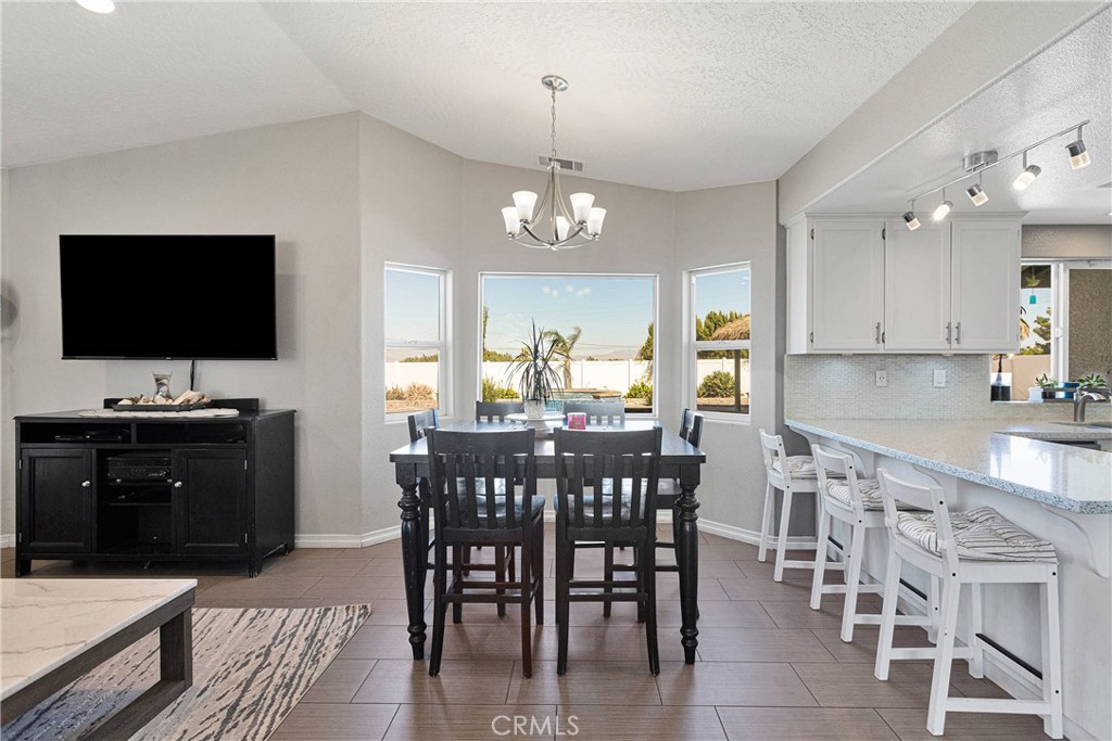 8621 Aster Road Oak Hills, CA 92344 - Photo 15 of 54 a view of a dining room with furniture and wooden floor