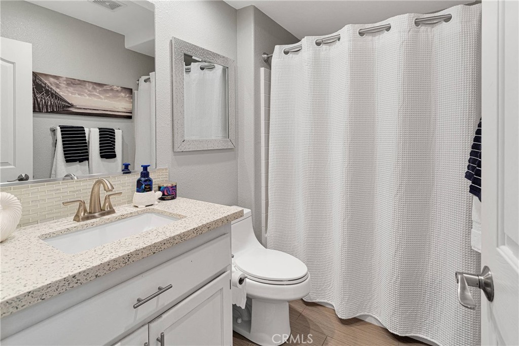 8621 Aster Road Oak Hills, CA 92344 - Photo 20 of 54 a bathroom with a granite countertop sink toilet and mirror