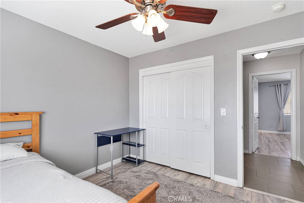 8621 Aster Road Oak Hills, CA 92344 - Photo 22 of 54 a bedroom with a bed and a chandelier