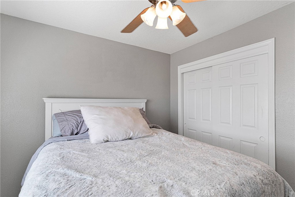 8621 Aster Road Oak Hills, CA 92344 - Photo 24 of 54 a bedroom with a bed and a window