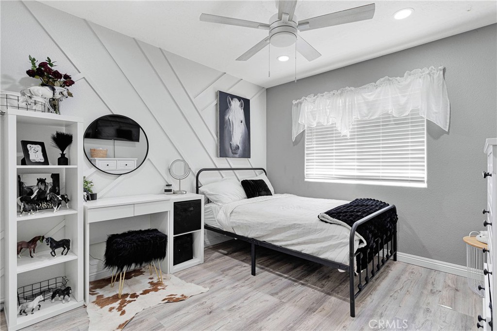 8621 Aster Road Oak Hills, CA 92344 - Photo 26 of 54 a bedroom with a bed a window and a chandelier