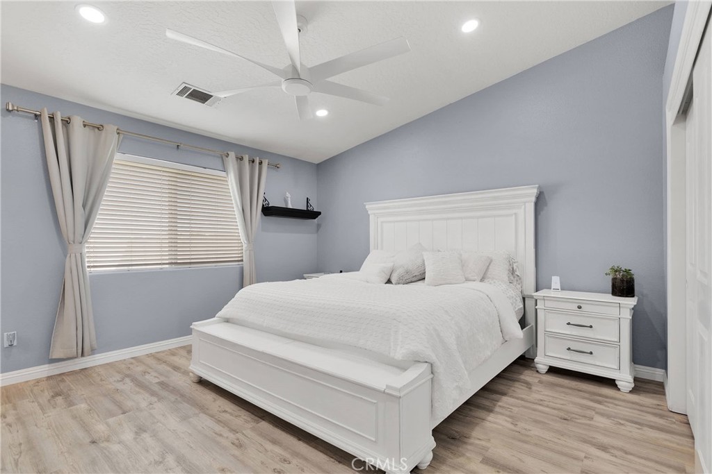 8621 Aster Road Oak Hills, CA 92344 - Photo 27 of 54 a bedroom with a bed and a window