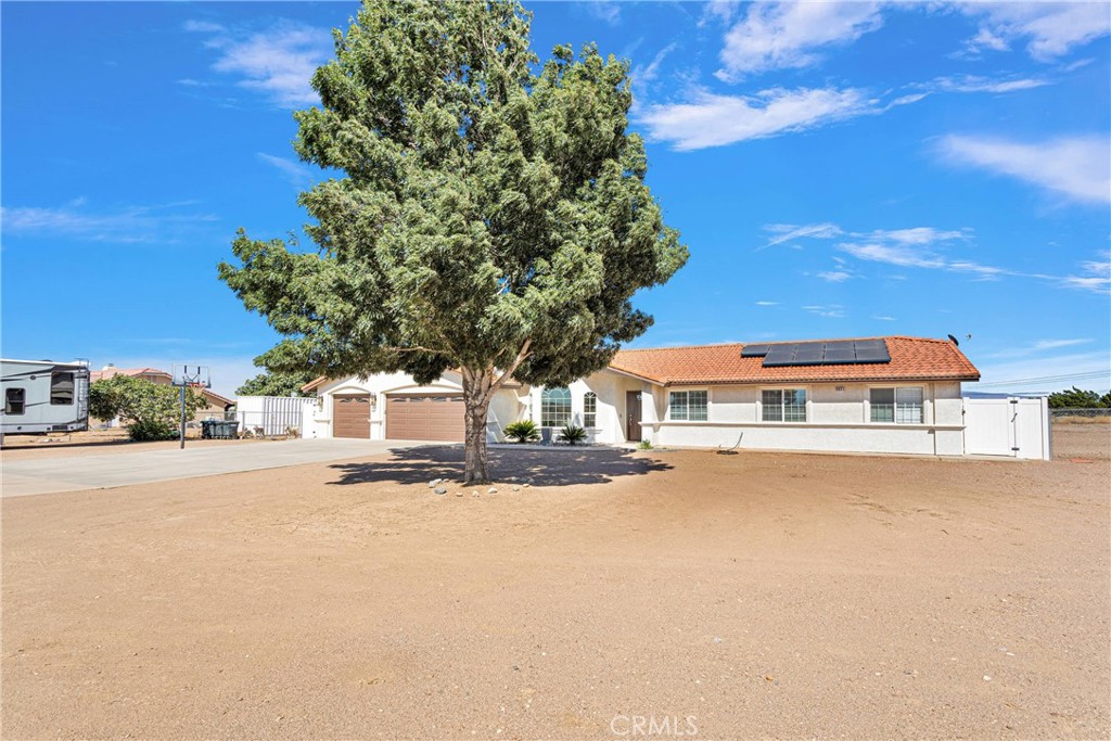 8621 Aster Road Oak Hills, CA 92344 - Photo 3 of 54 a front view of a house with a yard and garage