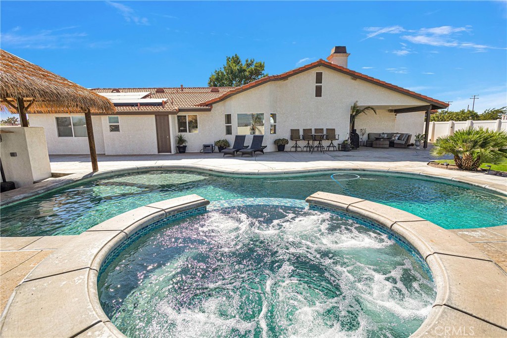 8621 Aster Road Oak Hills, CA 92344 - Photo 39 of 54 a view of a white house with a big yard and potted plants