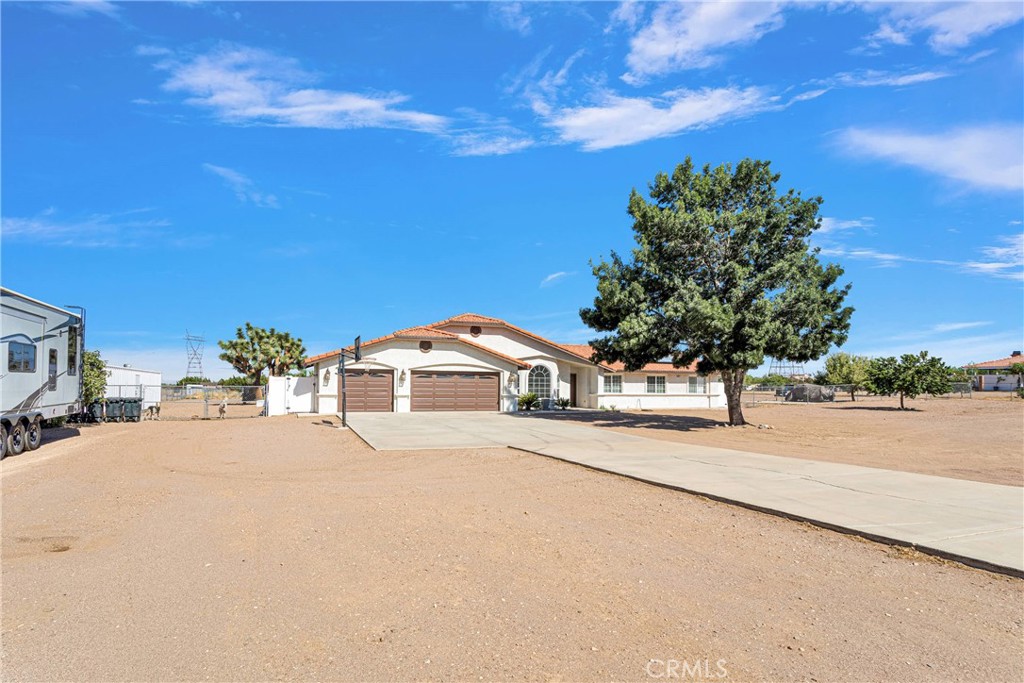 8621 Aster Road Oak Hills, CA 92344 - Photo 4 of 54 a front view of a house with a yard and garage
