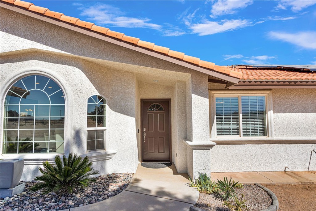8621 Aster Road Oak Hills, CA 92344 - Photo 6 of 54 a front view of a house with a garden
