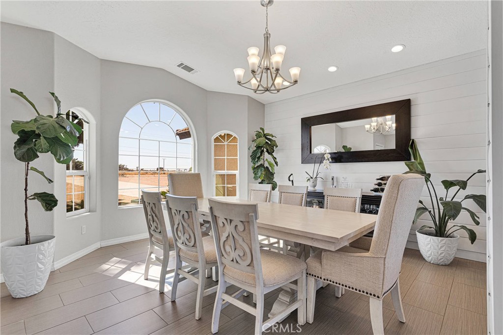 8621 Aster Road Oak Hills, CA 92344 - Photo 8 of 54 a view of a dining room with furniture a livingroom and chandelier
