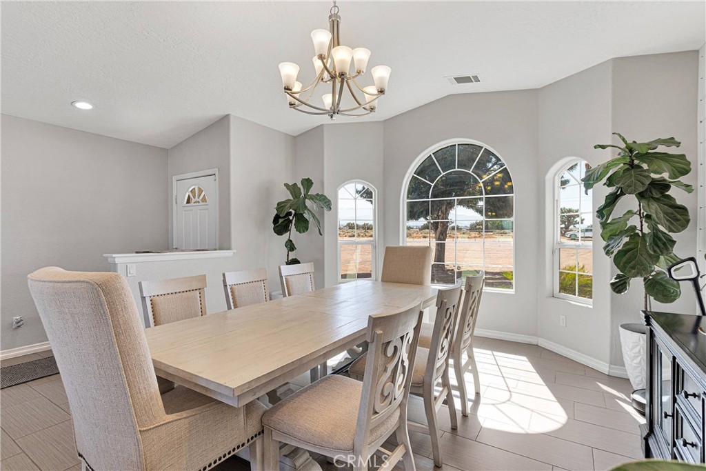 8621 Aster Road Oak Hills, CA 92344 - Photo 9 of 54 a view of a dining room with furniture a chandelier and wooden floor