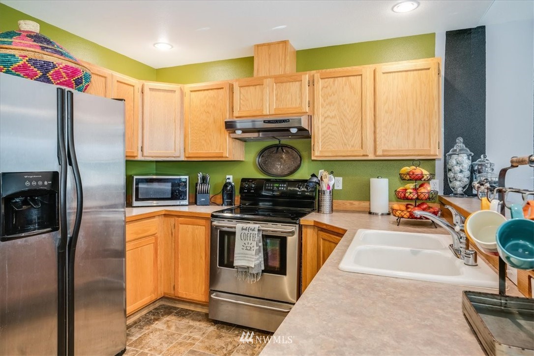 7610 187th Avenue Southwest Rochester, WA 98579 - Photo 13 of 39 a kitchen with stainless steel appliances granite countertop a stove a refrigerator and a sink
