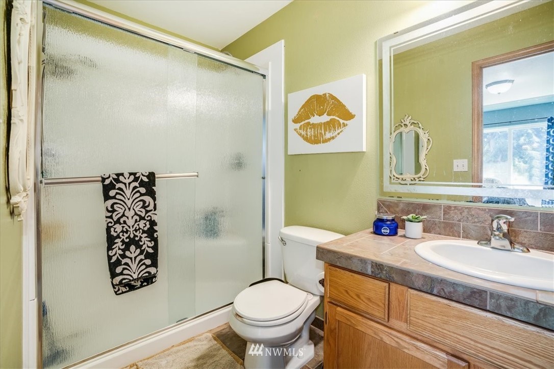 7610 187th Avenue Southwest Rochester, WA 98579 - Photo 23 of 39 a bathroom with a granite countertop sink toilet and a mirror