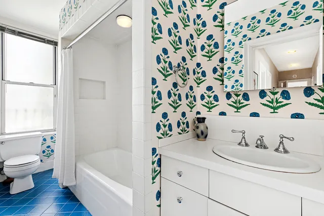 a bedroom with a bed book shelf and a window