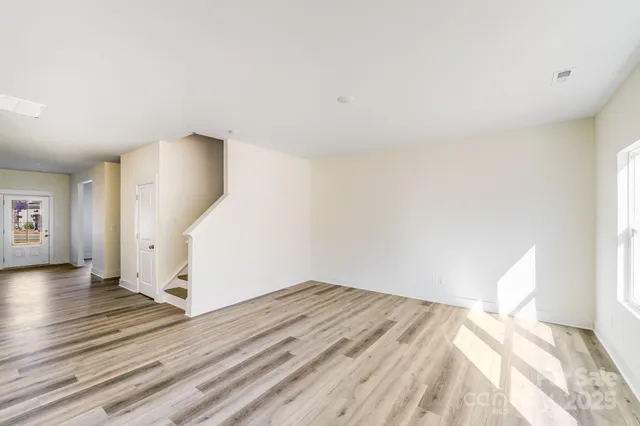 a view of a room with wooden floor and a window