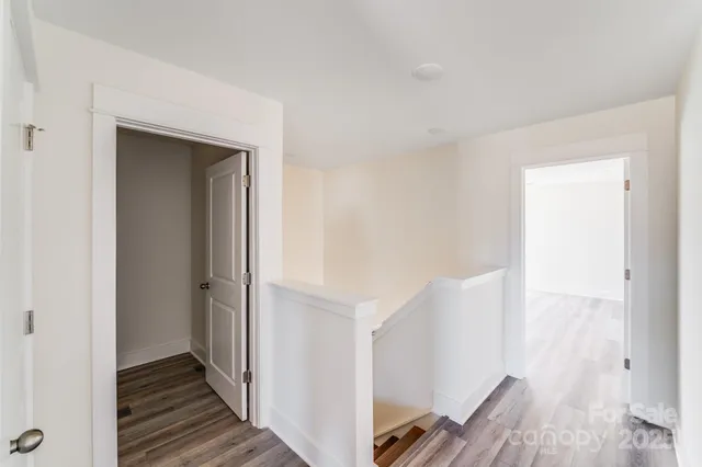 a view of a hallway with wooden floor and staircase