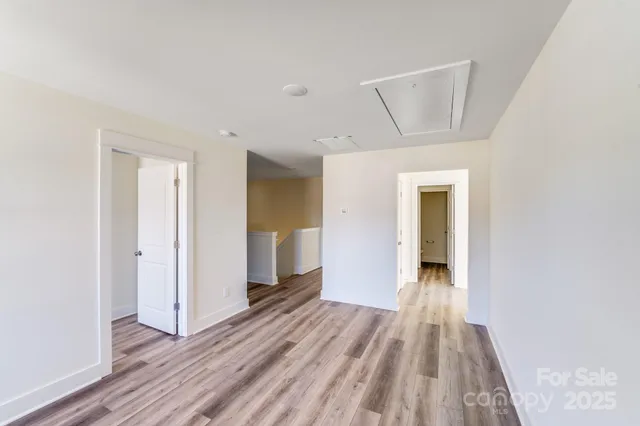 a view of a hallway with wooden floor and closet