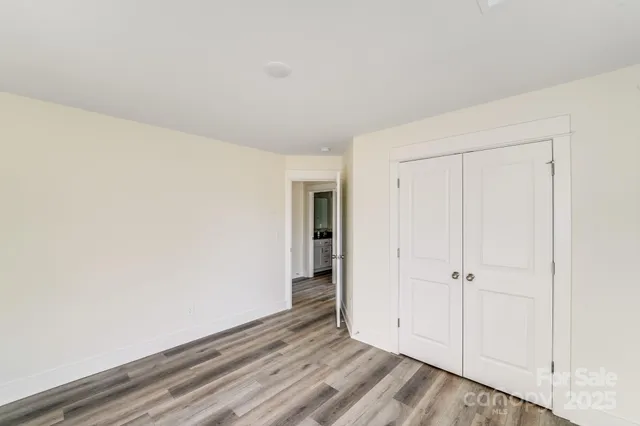 an empty room with wooden floor and closet