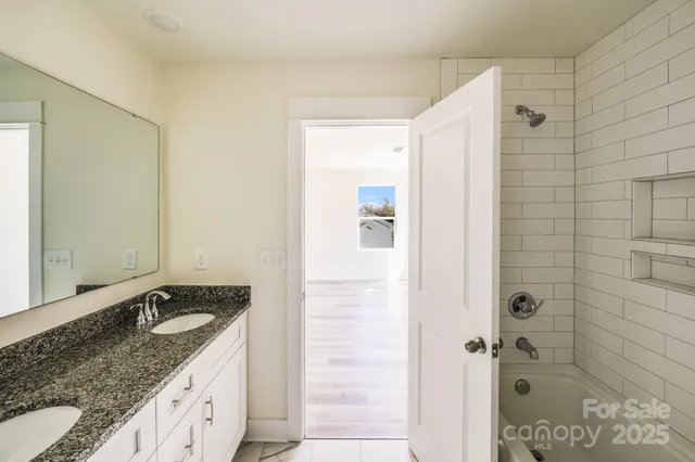 a bathroom with a granite countertop sink and shower
