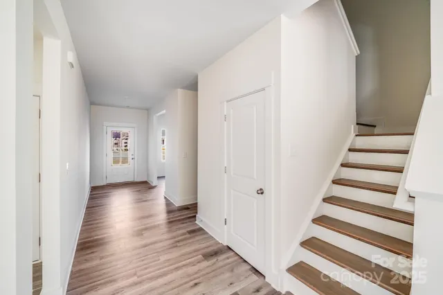 a view of a hallway with wooden floor and entryway