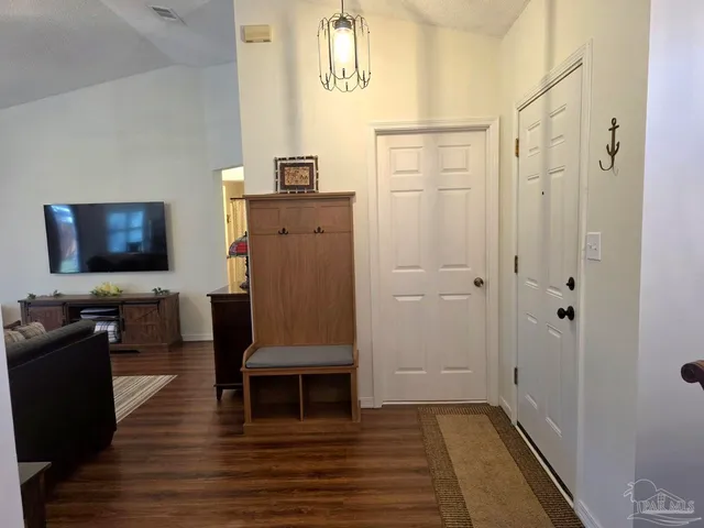 a living room with furniture a flat screen tv and kitchen view