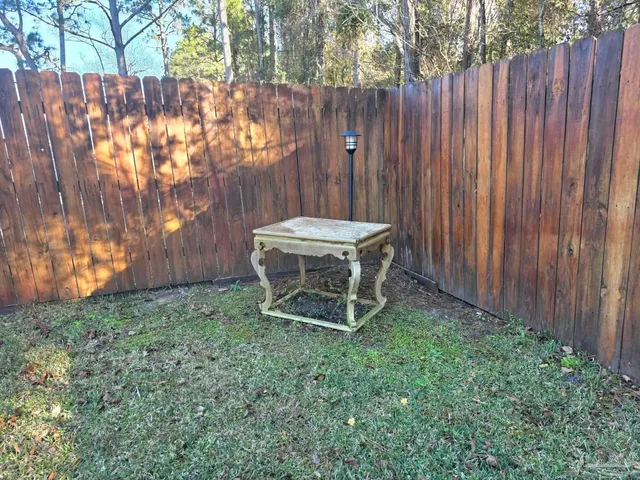 a view of a backyard with wooden fence