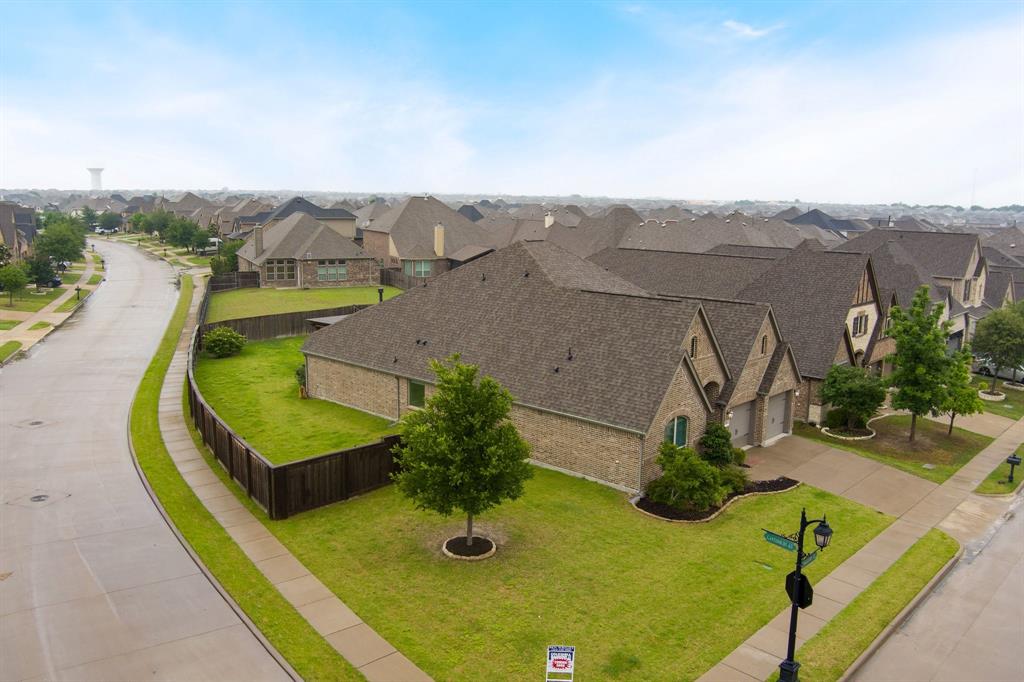 1501 Calcot Lane Forney, TX 75126 - Photo 34 of 34 Brick exterior featuring a hip and gable roofline, attached two-car garage, and a fenced backyard