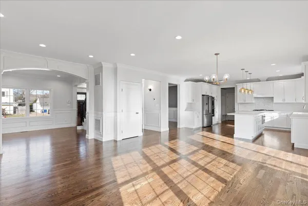 a large kitchen with a lot of white appliances cabinets and wooden floor
