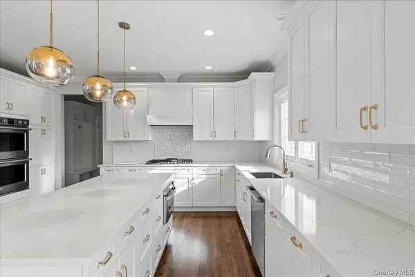 a large kitchen with stainless steel appliances kitchen island granite countertop a sink a stove and a wooden floors