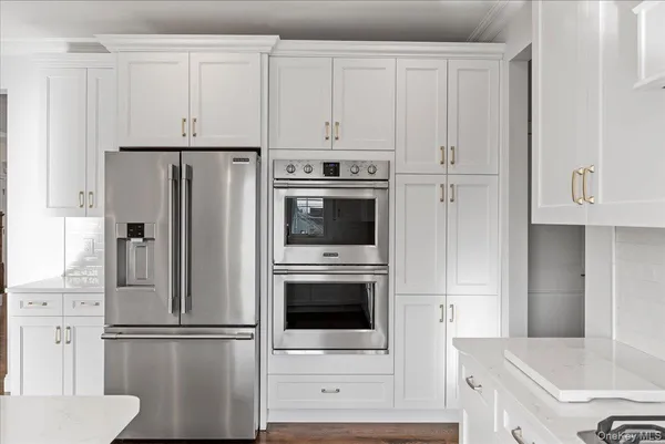 a kitchen with stainless steel appliances white cabinets and a refrigerator