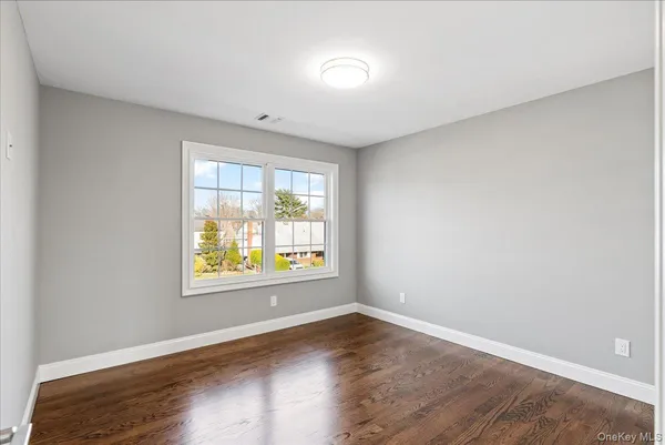a large white kitchen with granite countertop a stove a sink a oven and a fireplace with wooden floor