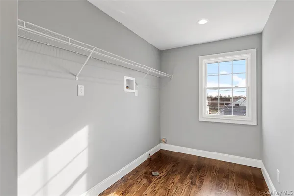 an empty room with wooden floor and a window