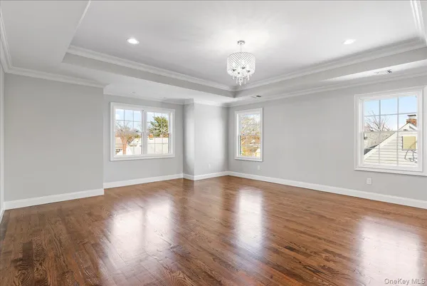 a view of a hallway with wooden floor and windows