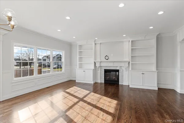 a view of an empty room with a window and fireplace